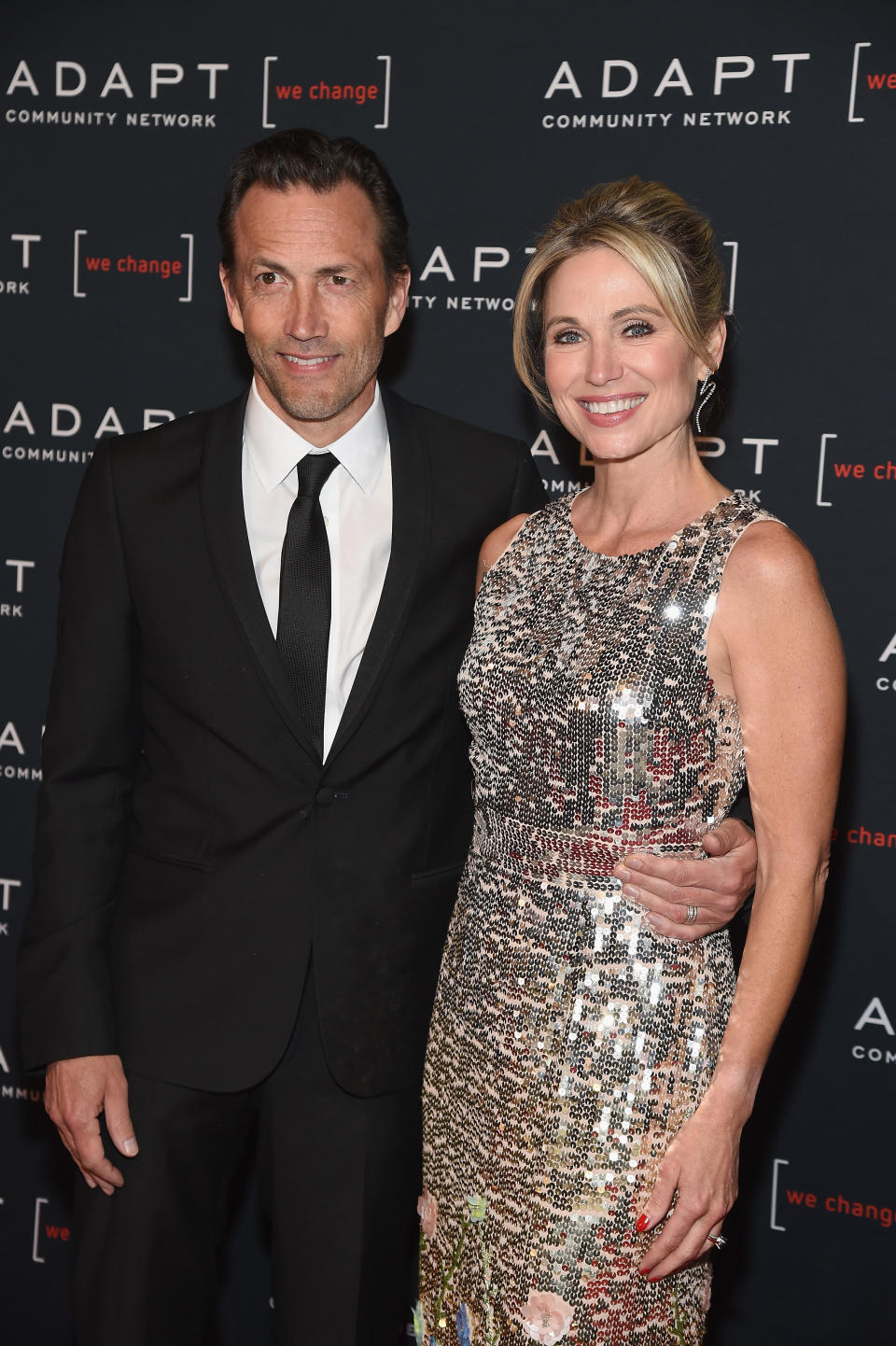Amy Robach wears sequined dress with halter neck next to Andrew Shue