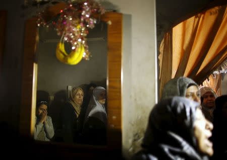 Relatives of Palestinian militant Mussa Zeater, who was killed in an attack by an Israeli aircraft, are reflected in a mirror as they mourn during his funeral in the northern Gaza Strip January 13, 2016. REUTERS/Mohammed Salem