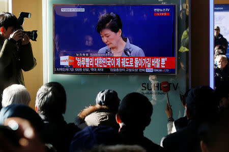 People watch a television broadcast of a news report on President Park Geun-hye releasing a statement to the public in Seoul, South Korea, November 29, 2016. REUTERS/Kim Hong-Ji