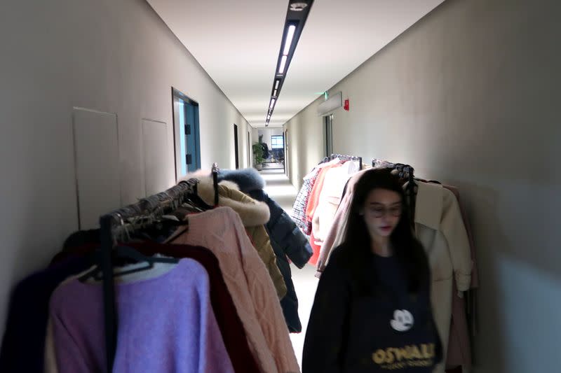 Online Chinese celebrity and store owner Zhang Dayi walks past clothing rails as she heads to a live-streaming session for "Double 12" in Hangzhou