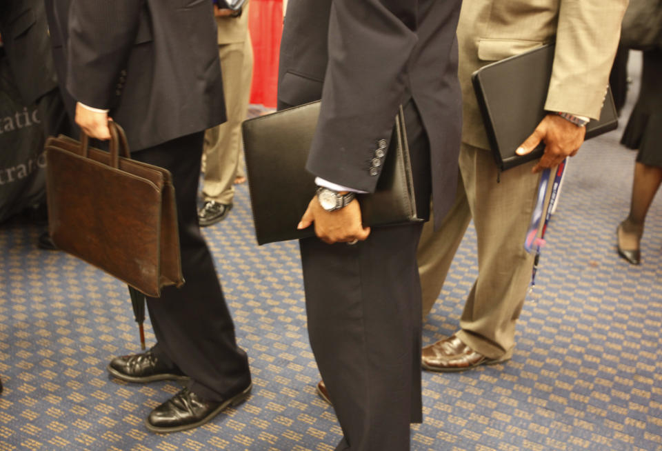 Attendees at a job fair line up for an interview carrying their resumes in leather bags in a Washington hotel, August 6, 2009. The number of U.S. workers filing new claims for jobless benefits fell sharply last week, a government report showed on Thursday, boosting views that the labor market and the economy were stabilizing.    REUTERS/Jason Reed   (UNITED STATES BUSINESS EMPLOYMENT)