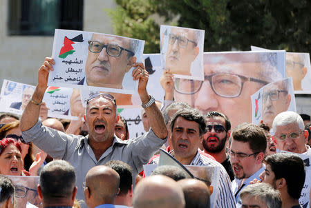 Relatives and activists hold pictures of Jordanian writer Nahed Hattar, who was shot dead, and shout slogans during a sit-in in front of the prime minister's building in Amman, Jordan, September 26, 2016. REUTERS/Muhammad Hamed