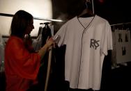 FILE PHOTO: A fashion assistant steams an item backstage before the DKNY London Collections: Men show in London
