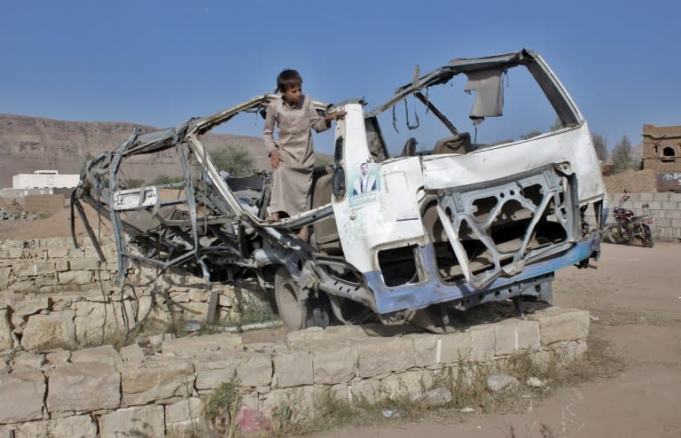 A Yemeni boy on September 4, 2018 stands in the wreckage of the bus which was hit by a Saudi-led coalition air strike