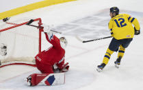 Sweden's Noah Ostlund (12) scores on Czechia goaltender Michael Hrabal (30) during the third period of a semifinal hockey game at the IIHF World Junior Hockey Championship in Gothenburg, Sweden, Thursday Jan. 4, 2024. (Christinne Muschi/The Canadian Press via AP)