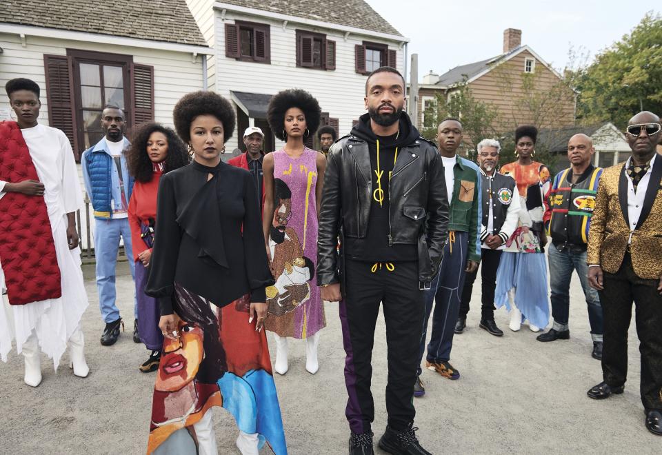“My work always revolves around justice and equality.” —Kerby Jean-Raymond
Jean-Raymond (center) with a colorful cast of his model, musician, and actor friends—along with his father, Jean-Claude (left, in white cap)—and Dapper Dan (far right) at the Weeksville Heritage Center in Brooklyn. Fashion Editor: Alex Harrington.