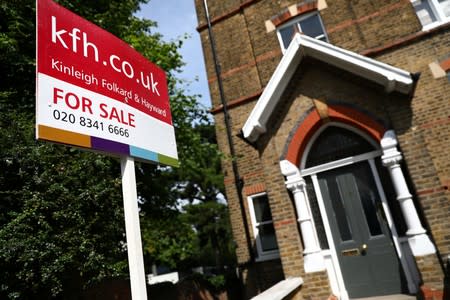 An estate agent board is displayed outside a property in London