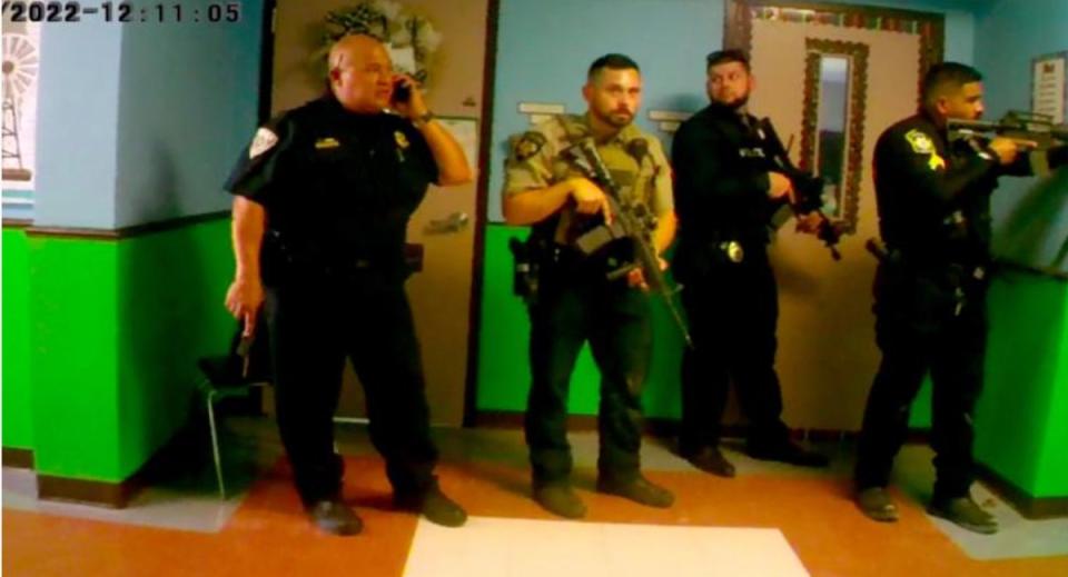 Bodycam shows armed officers and Uvalde School Police Chief Pete Arredondo outside the classroom failing to go in during the massacre (EPA)