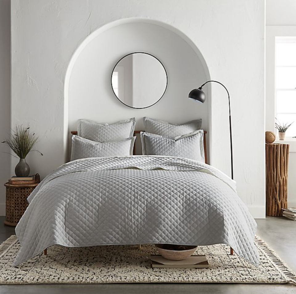 grey Linen/Cotton 3-Piece King Quilt Set next to white walls and circle mirror