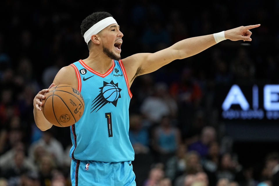 Phoenix Suns guard Devin Booker (1) calls a play during the second half of an NBA basketball game against the San Antonio Spurs, Tuesday, April 4, 2023, in Phoenix. (AP Photo/Matt York)