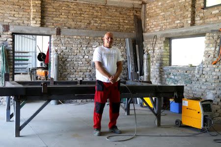 Welder Kracsun poses for a photo in his workshop in Cantavir, Serbia, July 6, 2017, after a grant received from the Hungarian government enabled him to buy new machinery, boosting the amount of work he can take on. REUTERS/Bernadett Szabo