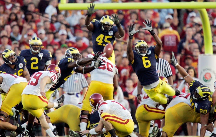 The photo, taken from behind the offense, shows the ball fly off of Danelo's foot while several Michigan defenders leap to try and block the kick.
