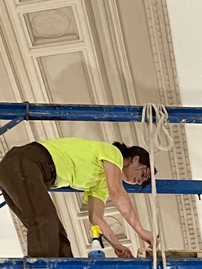 Carrie Miller, another artisan with Building Arts & Conservation, painted gold accents on the community room ceiling. Miller joined Koenig’s team about a year ago. “Her dad is a cabinet maker. She’s worked in art all her life,” Koenig said.