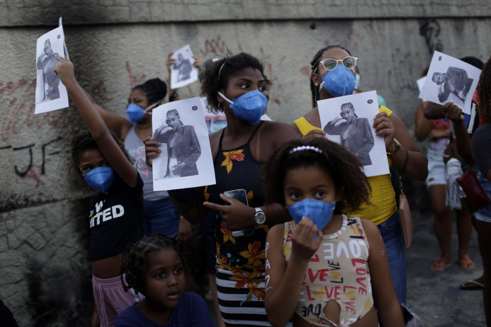 Residents carry flyers with the image of Kathlen Romeu, a young pregnant woman killed by a stray bullet, in Rio de Janeiro, Brazil, Wednesday, June 9, 2021. Stray bullets have struck at least six pregnant women in Rio since 2017, but Romeu was the first to die, according to Crossfire, a non-governmental data project that tracks armed violence. (AP Photo/Bruna Prado)