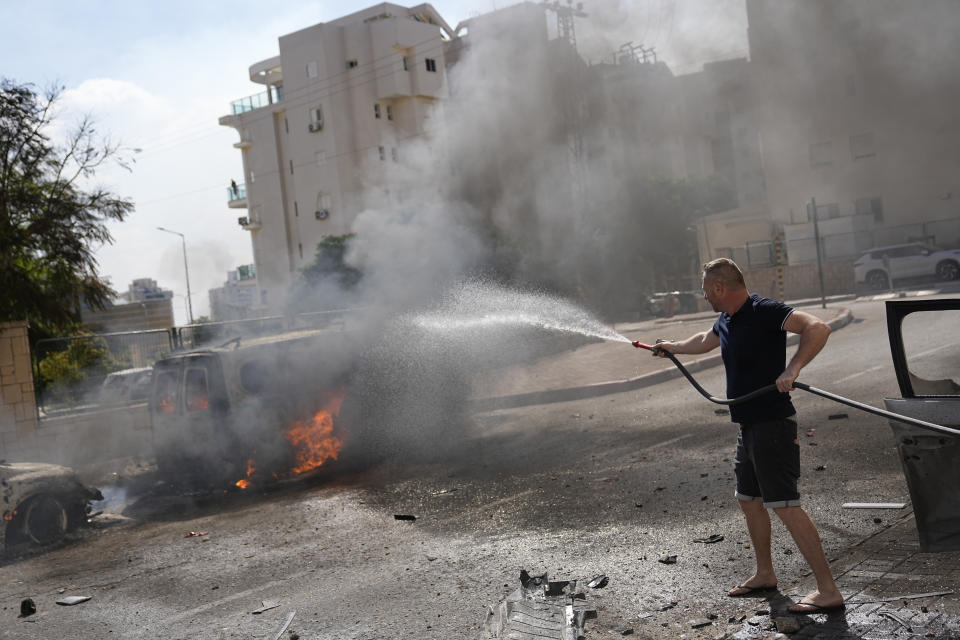 FILE - Cars are on fire after they were hit by rockets from the Gaza Strip in Ashkelon, Israel, on Oct. 7, 2023. Since Russia invaded Ukraine in February 2022, more than 45,000 Ukrainians have sought refuge in Israel. Then, Israel's war erupted. Now many are reliving their trauma. Some have left Israel, but many remain — refusing to again flee a war. (AP Photo/Ohad Zwigenberg, File)