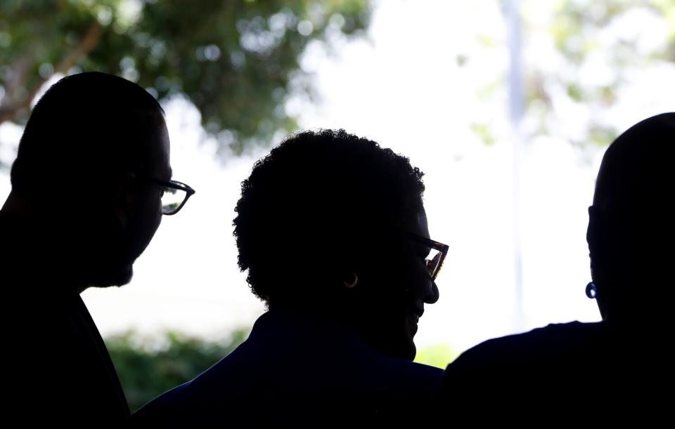 A silhouette of mayoral candidate Karen Bass, center, and two other people.