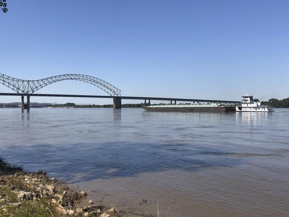 A boat hauling barges down the Mississippi River moves toward the Interstate 40 bridge linking Tennessee and Arkansas on Friday, May 14, 2021, in Memphis, Tenn. The U.S. Coast Guard reopened a section of the river near Memphis on Friday, three days after river traffic was shut down when a crack was found in the bridge. (AP Photo/ Adrian Sainz)