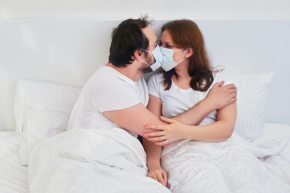 <span class="caption">Is it safe for a man to have sex after recovering from COVID-19?</span> <span class="attribution"><a class="link " href="https://www.gettyimages.com/detail/photo/couple-kissing-in-bed-in-medical-mask-family-royalty-free-image/1249152242?adppopup=true" rel="nofollow noopener" target="_blank" data-ylk="slk:Andrey Zhuravlev / Getty Images;elm:context_link;itc:0;sec:content-canvas">Andrey Zhuravlev / Getty Images</a></span>