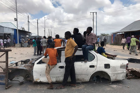 Protesters use the wreckage of a car to block the street during fighting between the military and police, backed by intelligence forces in the Dayniile district of Mogadishu, Somalia September 16, 2017. REUTERS/Feisal Omar