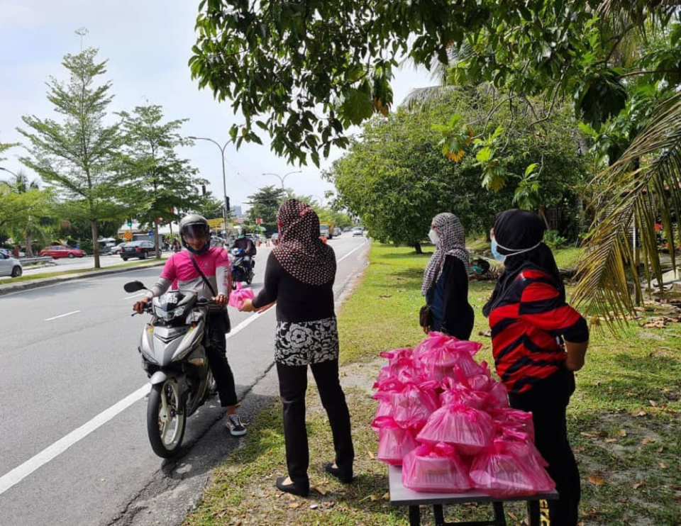 A Foodpanda delivery rider picking up food at the give out point at Jalan Cahaya in front of Taman Nirwana, Ampang on Wednesday. — Picture via Facebook/ Ida Azarin Razali