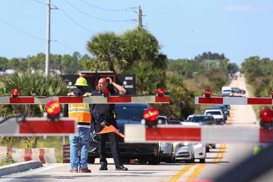 Cars line up as a Brightline train prepares to pass through the intersection of SE Walton Road near Savannas Preserve State Park, during a test reaching speeds of 110 mph on Friday, Oct. 21, 2022. 