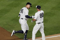 New York Yankees third base coach Phil Nevin (88) congratulates Aaron Judge (99) ater Judge hit a two-run home run in the eighth inning of the team's baseball game against the Boston Red Sox, Sunday, Aug. 2, 2020, at Yankee Stadium in New York. (AP Photo/Kathy Willens)