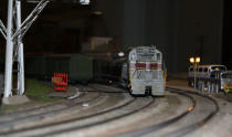 A trains pulls around a corner at night. After 67 years in the Liberty Village location, The Model Railroad Club of Toronto will be moving to make way for a condo.