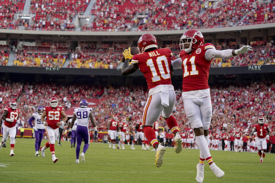 Kansas City Chiefs wide receiver Tyreek Hill (10) is congratulated by teammate wide receiver Demarcus Robinson (11) after scoring during the first half of an NFL football game against the Minnesota Vikings Friday, Aug. 27, 2021, in Kansas City, Mo. (AP Photo/Charlie Riedel)