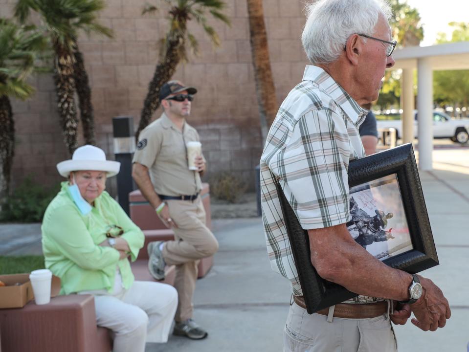 Norm King, left, holds a photograph of Frank Bogert while attending the removal of Bogert's statue in front of Palm Springs City Hall in 2022.