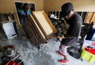 Micheal Andrews (R) and his friend Clarence Robertson remove furniture out of his flood damaged home at the South Point subdivision in Denham Springs, Louisiana, U.S., August 22, 2016. REUTERS/Jonathan Bachman