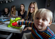 The youngest child Fritz (19 months) sits next to his sister Milena (21) at a table in their home in Eisemroth, central Germany, Thursday, March 25, 2021. One year into the coronavirus pandemic, Katja Heimann is still trying to keep her spirits up - despite several lockdowns and months of teaching seven of her children in home schooling. (AP Photo/Michael Probst)