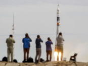 Photographers take pictures as the Soyuz TMA-18M spacecraft carrying the crew of Aidyn Aimbetov of Kazakhstan, Sergei Volkov of Russia and Andreas Mogensen of Denmark blasts off from the launch pad at the Baikonur cosmodrome, Kazakhstan, September 2, 2015. REUTERS/Shamil Zhumatov