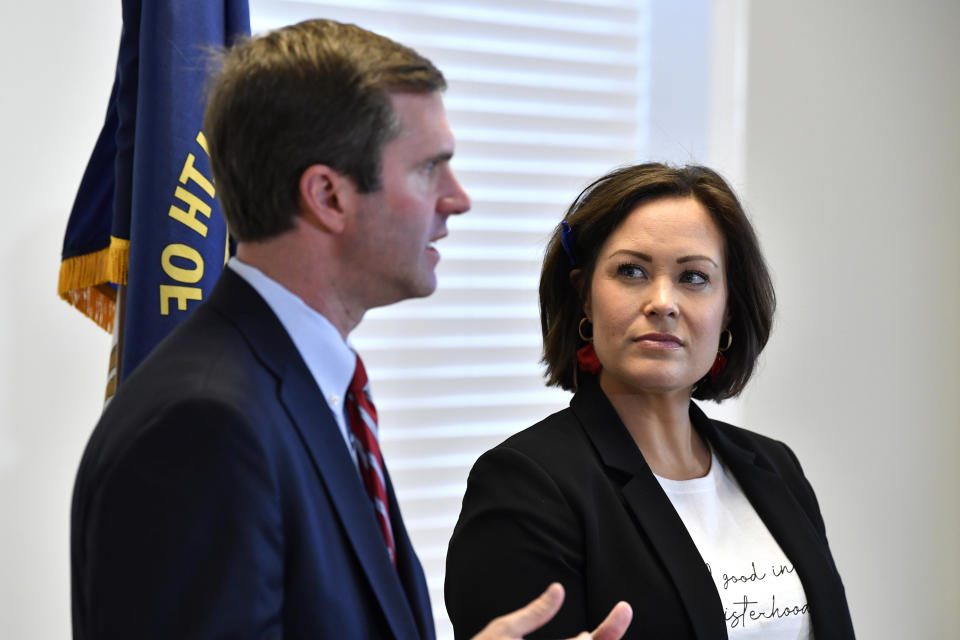 FILE - In this Nov. 14, 2019, file photo, Kentucky Lt. Gov.-elect Jacqueline Coleman, right, looks on as Gov.-elect Andy Beshear speaks with reporters following the concession of incumbent Governor Matt Bevin in Frankfort, Ky. It's a role that seems scripted for Coleman, as an educator transitioning to the job as a "full partner" in a Democratic administration that vows to make public education a top priority. (AP Photo/Timothy D. Easley, File)