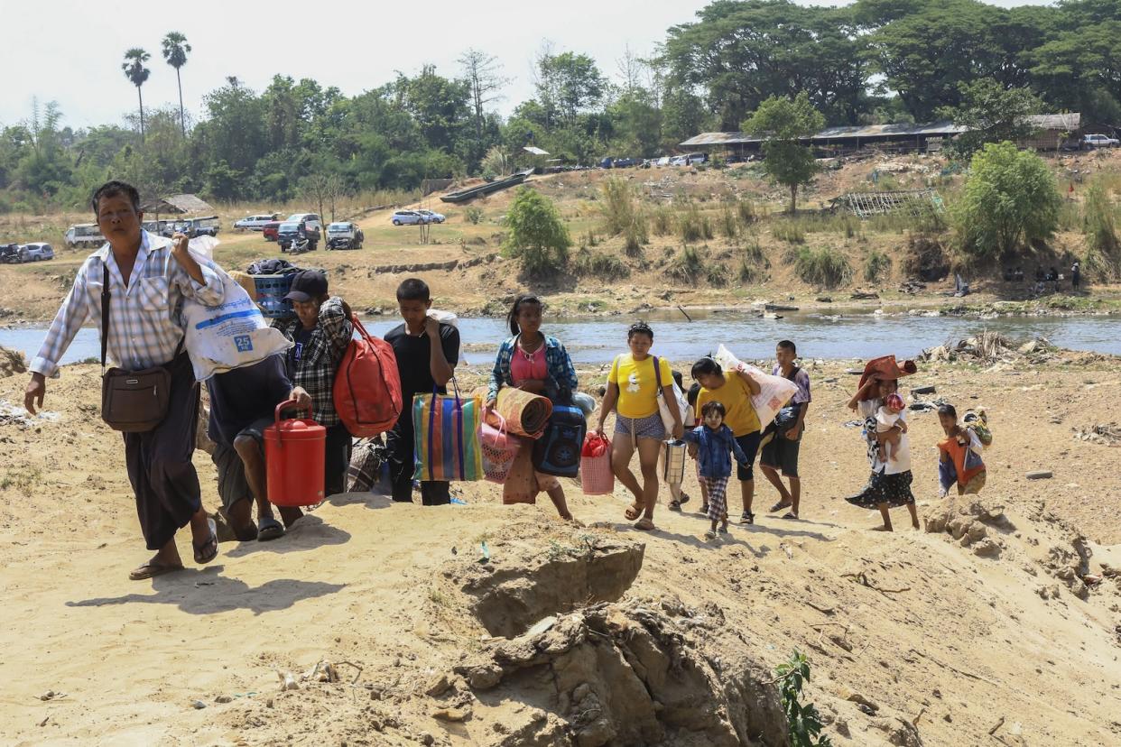 People cross the Moei river as they flee Myawaddy township in Myanmar to Thailand's Mae Sot town in Thailand's Tak province, Saturday, April 20, 2024. More than a thousand people have fled from eastern Myanmar into Thailand on Saturday as fresh fighting erupted near the border of the town that has recently been captured by guerillas from the Karen ethnic minority, officials said.(AP Photo/Warangkana Wanichachewa)