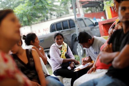 Eufemia Garcia, 48, who lost 50 members of her family during the eruption of the Fuego volcano, sits with other residents outside the morgue in Escuintla, Guatemala, June 11, 2018. REUTERS/Carlos Jasso