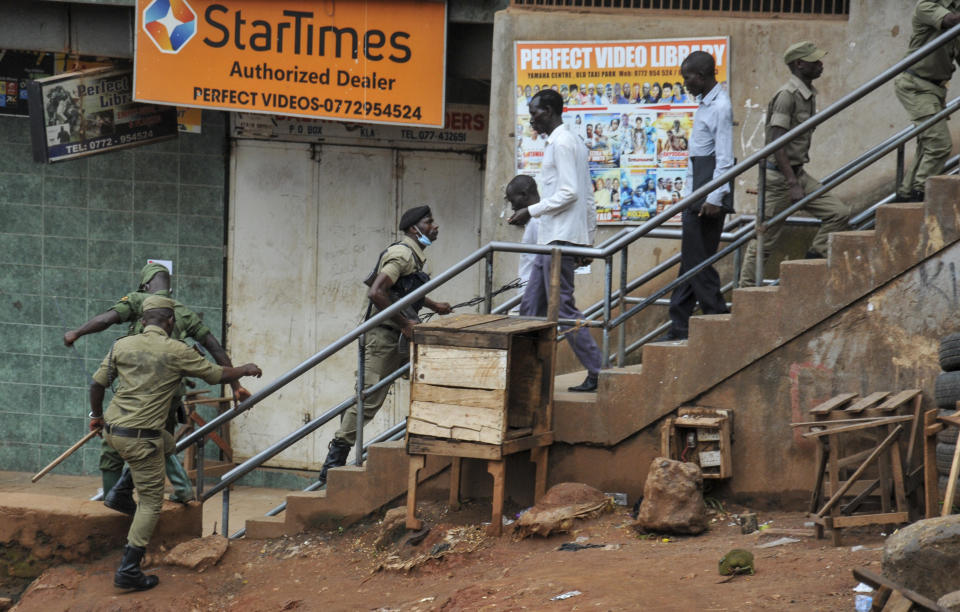 Ugandan police and other security forces chase people off the streets to avoid unrest, after police cleared a stand of motorcycle taxis which are no longer permitted to operate after all public transport was banned for two weeks to halt the spread of the new coronavirus, in Kampala, Uganda Thursday, March 26, 2020. The new coronavirus causes mild or moderate symptoms for most people, but for some, especially older adults and people with existing health problems, it can cause more severe illness or death. (AP Photo/Ronald Kabuubi)