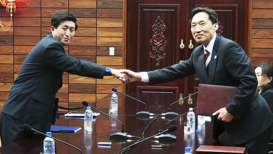 In this photo released by the South Korean Unification Ministry, head of the South Korean working-level delegation Lee Duk-haeng, right, shakes hands with his North Korean counterpart Park Yong Il after they exchanged documents of a signed agreement at Tongilgak in the North Korean side of Panmunjom which has separated the two Koreas since the Korean War, Wednesday, Feb. 5, 2014. The divided Koreas agreed Wednesday to hold the first reunions of war-divided families in more than three years later this month, in a surprise accord struck even Pyongyang is pressing its rival to cancel its annual military drills with Washington. (AP Photo/South Korean Unification Ministry)