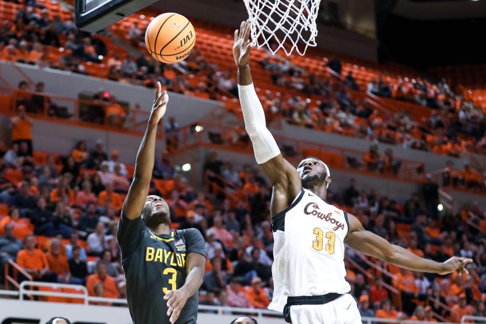 Baylor guard Dale Bonner (3) jumps to shoot as Oklahoma State forward Moussa Cisse (33) jumps to block in the first second during a college basketball game between the Oklahoma State Cowboys (OSU) and the Baylor Bears at Gallagher-Iba Arena in Stillwater, Okla., Monday, Feb. 27, 2023.
