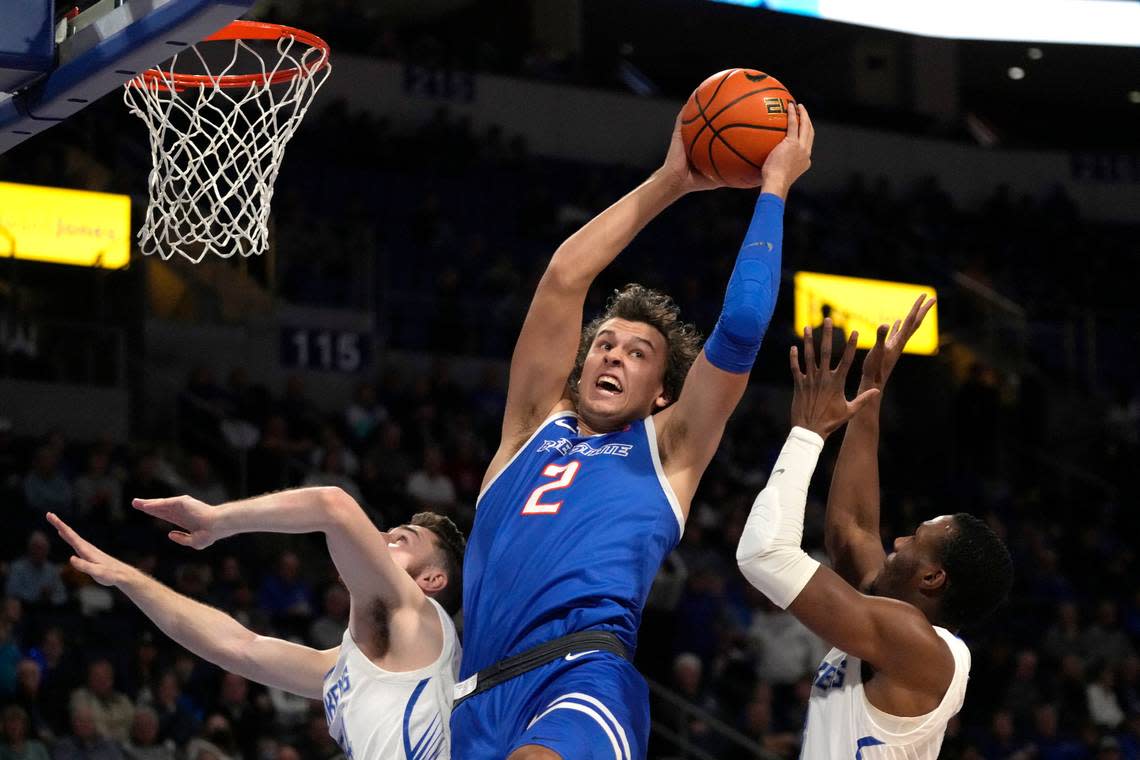 Boise State’s Tyson Degenhart (2) reaches for a rebound between Saint Louis’ Gibson Jimerson, left, and Javonte Perkins during the first half of an NCAA college basketball game Saturday, Dec. 10, 2022, in St. Louis. (AP Photo/Jeff Roberson)