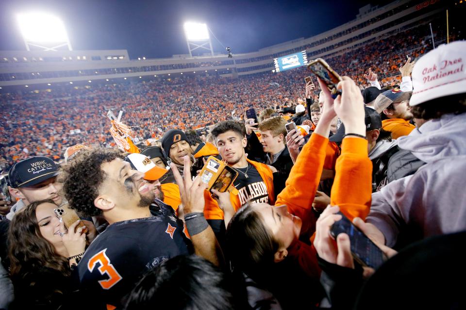 Oklahoma State's Spencer Sanders (3) celebrates with fans following a Bedlam college football game between the Oklahoma State University Cowboys (OSU) and the University of Oklahoma Sooners (OU) at Boone Pickens Stadium in Stillwater, Okla., Saturday, Nov. 27, 2021. OSU won 37-33.