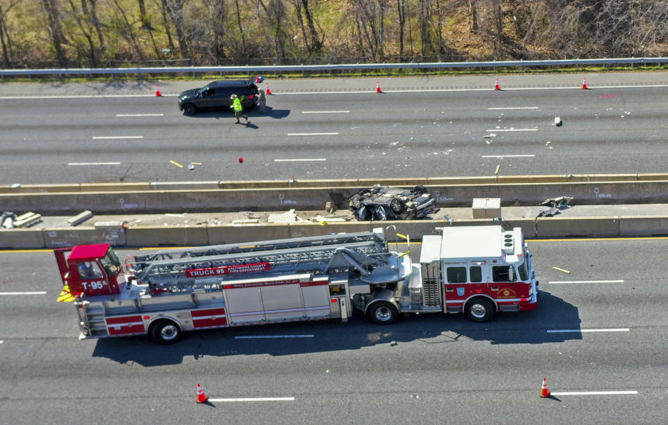 Emergency personnel work at the scene of fatal crash along Interstate 695 near Woodlawn, Md., Wednesday, March 22, 2023. At least six people were dead after a crash that closed the Baltimore Beltway in both directions Wednesday, snarling traffic along the west side of the highway that encircles the city, Maryland State Police said. (Jerry Jackson/The Baltimore Sun via AP)