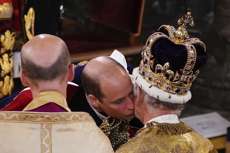 El príncipe Guillermo besa a su padre, el rey Carlos III, en la ceremonia de coronación en la Abadía de Westminster. (Yui Mok, Pool via AP)