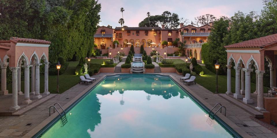 <p>The iconic Beverly Hills mansion where John and Jackie Kennedy spent their honeymoon is now on the market for $135 million, says <em><a rel="nofollow noopener" href="https://www.toptenrealestatedeals.com/homes/weekly-ten-best-home-deals/2018/10-08-2018/1/" target="_blank" data-ylk="slk:Top Ten Real Estate;elm:context_link;itc:0;sec:content-canvas" class="link ">Top Ten Real Estate</a>. </em>The home, "Beverly House," was originally owned by William Randolph Hearst and has been featured in <em>The Godfather </em>and <em>The Bodyguard</em><em>. </em></p><p>The mansion was designed in 1927 by Gordon Kaufmann, the same architect who designed the Hoover Dam, Hollywood Palladium, Los Angeles Times building, and the Santa Anita Racetrack. The 50,000 square foot home boasts 19 bedrooms, 29 bathrooms, a tennis court, two theaters, a two-story library, a state-of-the-art spa, and an 102 foot grand staircase. </p><p>Take a look through the stunning abode. </p>