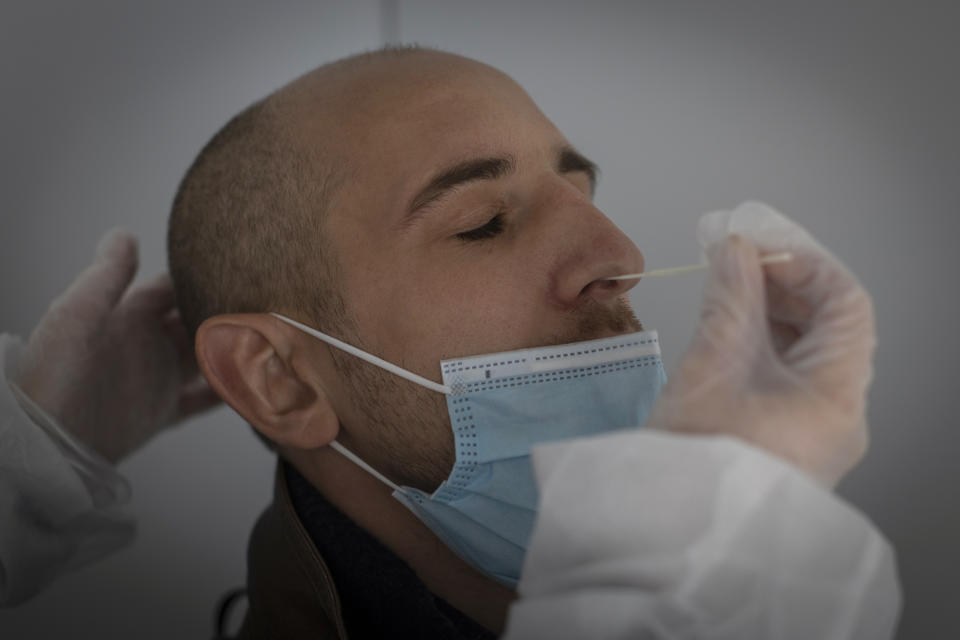 A medical worker performs a nasal swab test at a COVID-19 testing site, in Nantes, western France, Friday, Dec. 31, 2021. Paris region health authorities have instructed hospitals to cancel more non-urgent medical procedures to free up intensive-care beds for the growing influx of people gravely sick with COVID-19. (AP Photo/Jeremias Gonzalez)