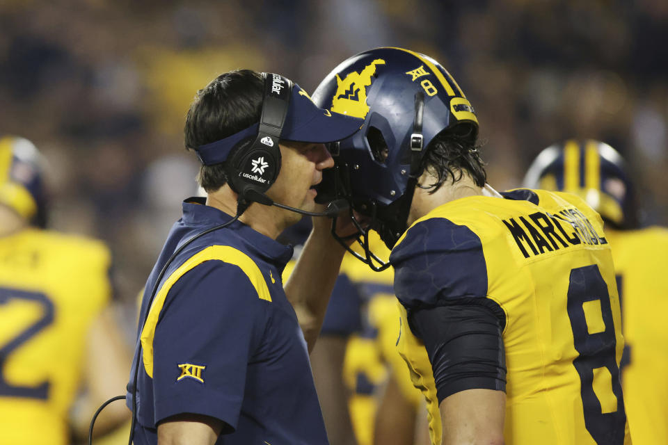 West Virginia head coach Neal Brown speaks with quarterback Nicco Marchiol (8) during the second half of an NCAA college football game, Saturday, Sept. 16, 2023, in Morgantown, W.Va. (AP Photo/Chris Jackson)