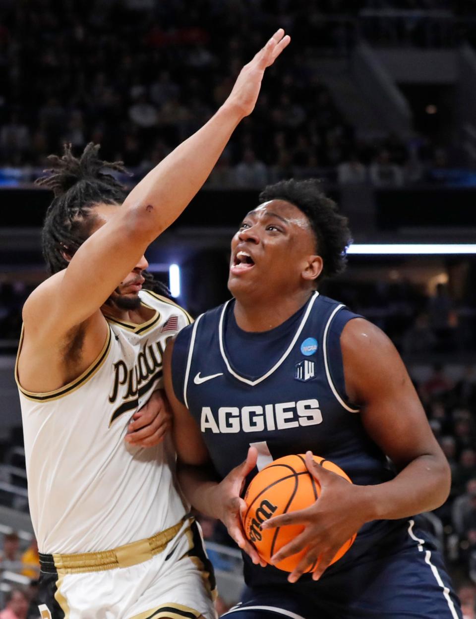 Purdue Boilermakers forward Trey Kaufman-Renn (4) protects Utah State Aggies forward Great Osobor (1) during the NCAA men's basketball tournament game, Sunday, March 24, 2024, at Gainbridge Fieldhouse in Indianapolis.