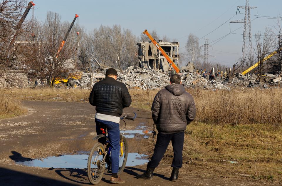 Men watch the clean-up in Makiivka (Reuters)