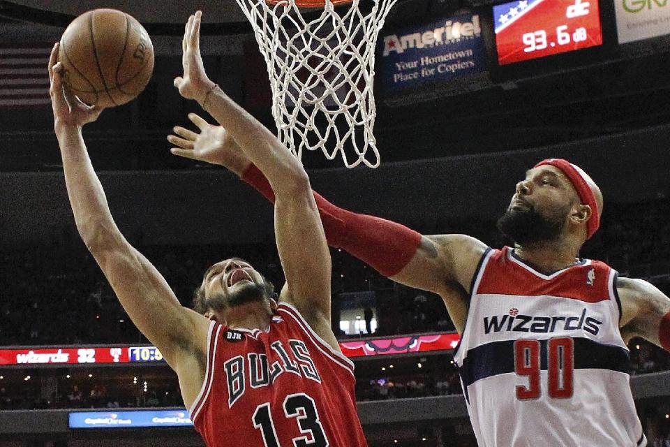 Joakim Noah (13) de los Bulls de Chicago intenta anotar ante Drew Gooden (90) de los Wizards de Washington en los playoffs de la NBA el domingo 27 de abril de 2014. (AP Foto/Alex Brandon)