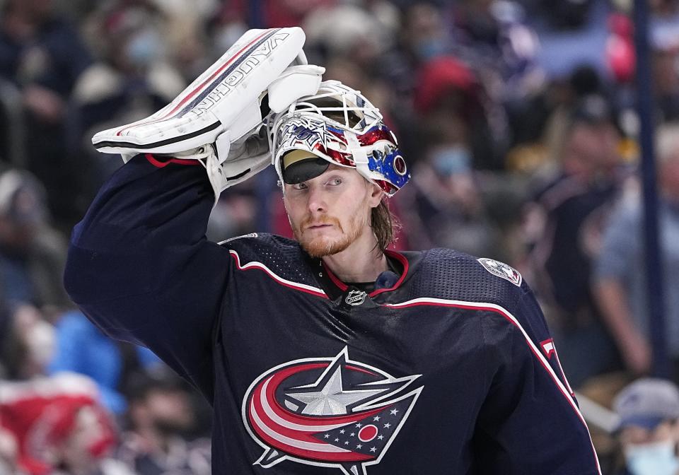 Columbus Blue Jackets goaltender Joonas Korpisalo (70) adjusts his mask during the second period of the NHL hockey game against the Pittsburgh Penguins at Nationwide Arena in Columbus on Friday, Jan. 21, 2022. 