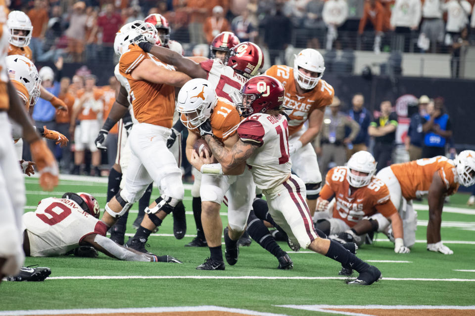 Texas Longhorns quarterback Sam Ehlinger (#11) fights his way into the end zone as Oklahoma Sooners linebacker Curtis Bolton (#18) tries to make the tackle during last season's Big 12 Championship game. (Getty)